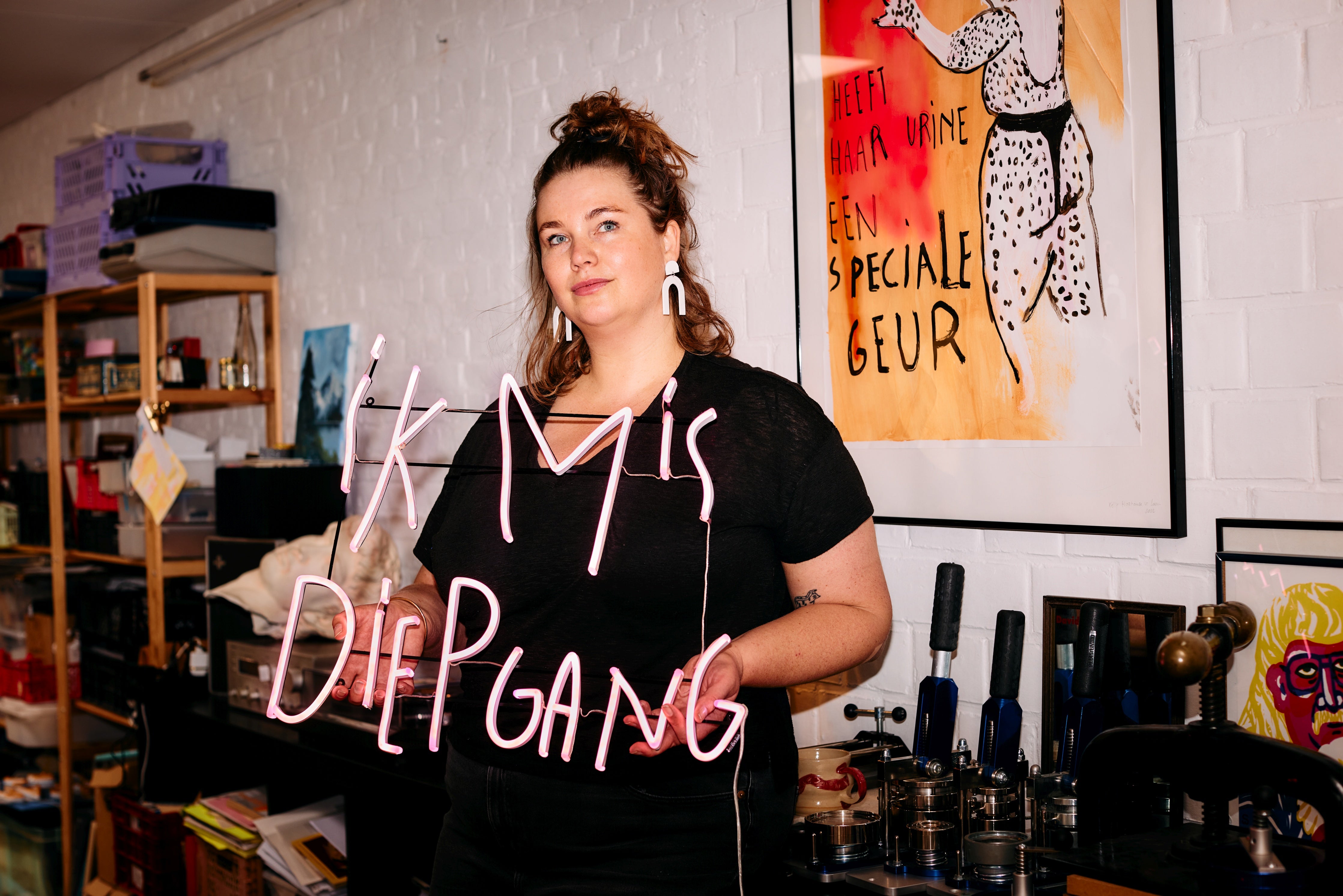 Kelly Hortense holding a LED Neon with the text "ik mis diepgang"